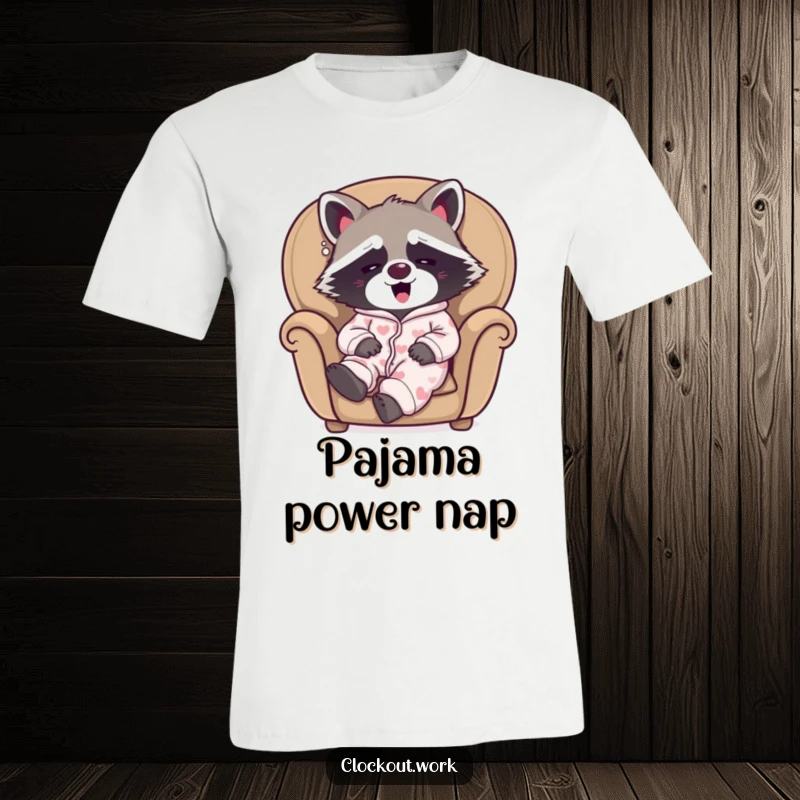 Funny t-shirt depicting a sleepy raccoon dressed in pajamas, yawning happily in a comfortable armchair.